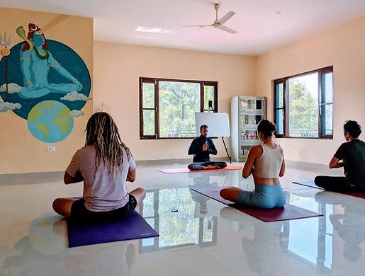 pranayama class being led in the hanuman hall of yoga ttc ashram in india