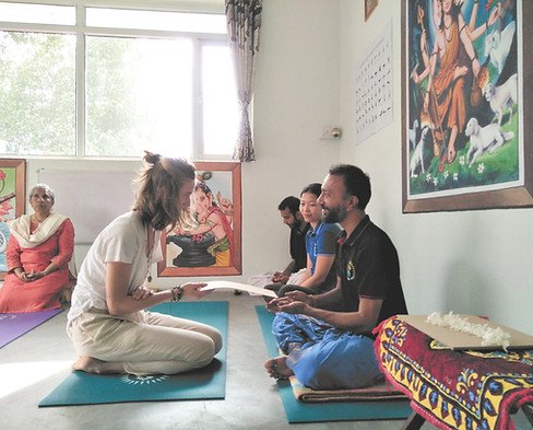 students being handed out their certificates after the completed the intensive yoga training course in India